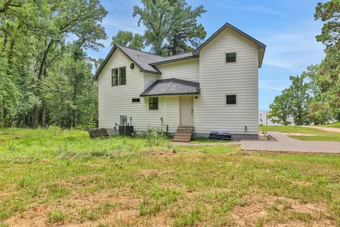 a view of a house with backyard and trees