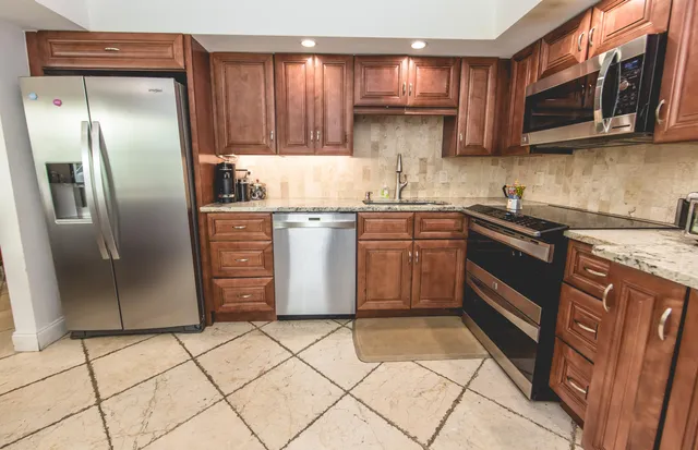 a kitchen with a refrigerator sink and cabinets