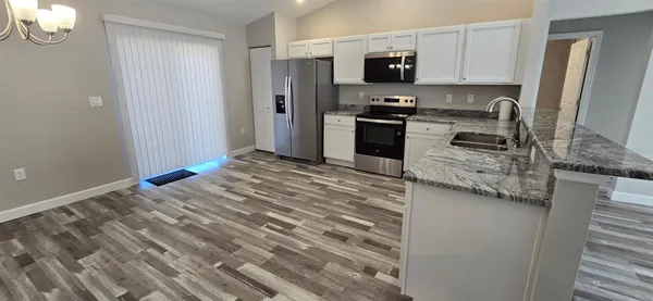 a kitchen with stainless steel appliances granite countertop a refrigerator stove and sink