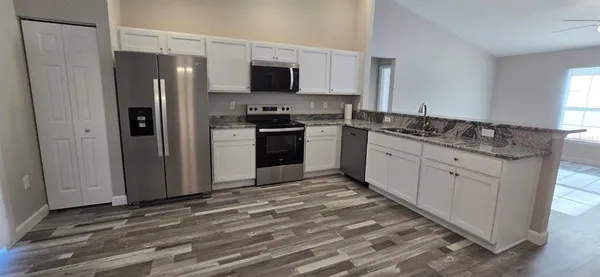 a kitchen with stainless steel appliances granite countertop a refrigerator stove and sink