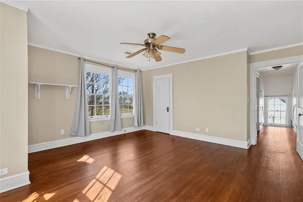 a view of a livingroom with wooden floor and a ceiling fan