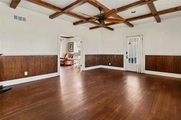 a view of a livingroom with wooden floor and a ceiling fan