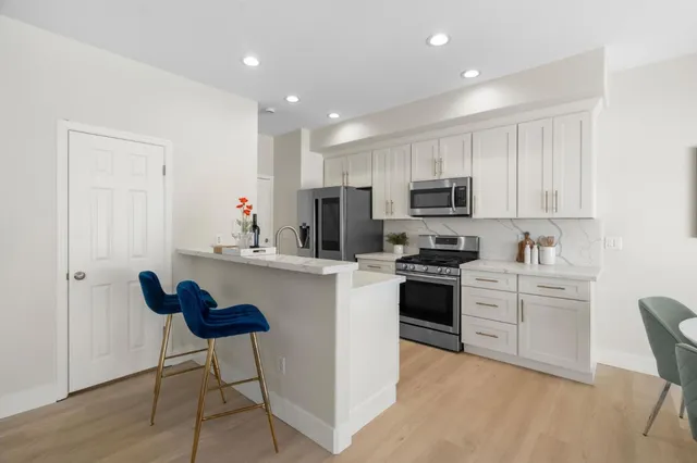a kitchen with cabinets a sink and a stove top oven with wooden floor