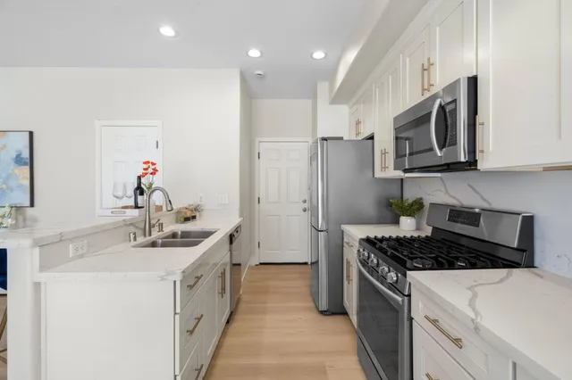 a kitchen with stainless steel appliances a sink stove and refrigerator