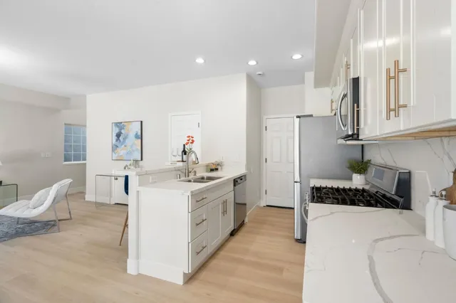 a kitchen with white cabinets and stainless steel appliances