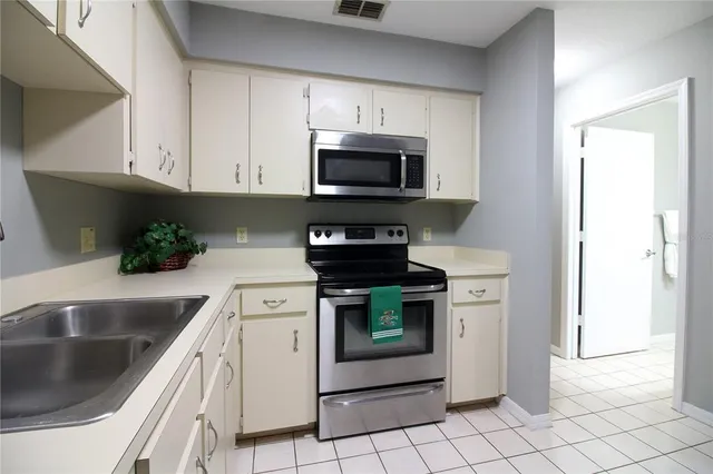 a kitchen with stainless steel appliances granite countertop a sink a stove a microwave and cabinets