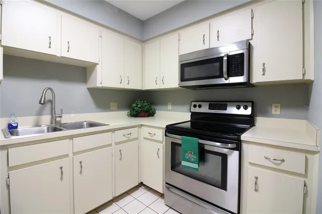 a kitchen with stainless steel appliances granite countertop white cabinets a stove a sink and dishwasher