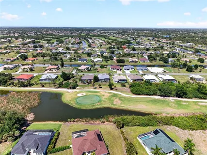 an aerial view of a house with swimming pool and a yard