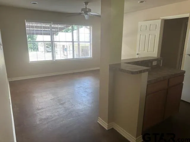 a view of hallway with window and wooden floor