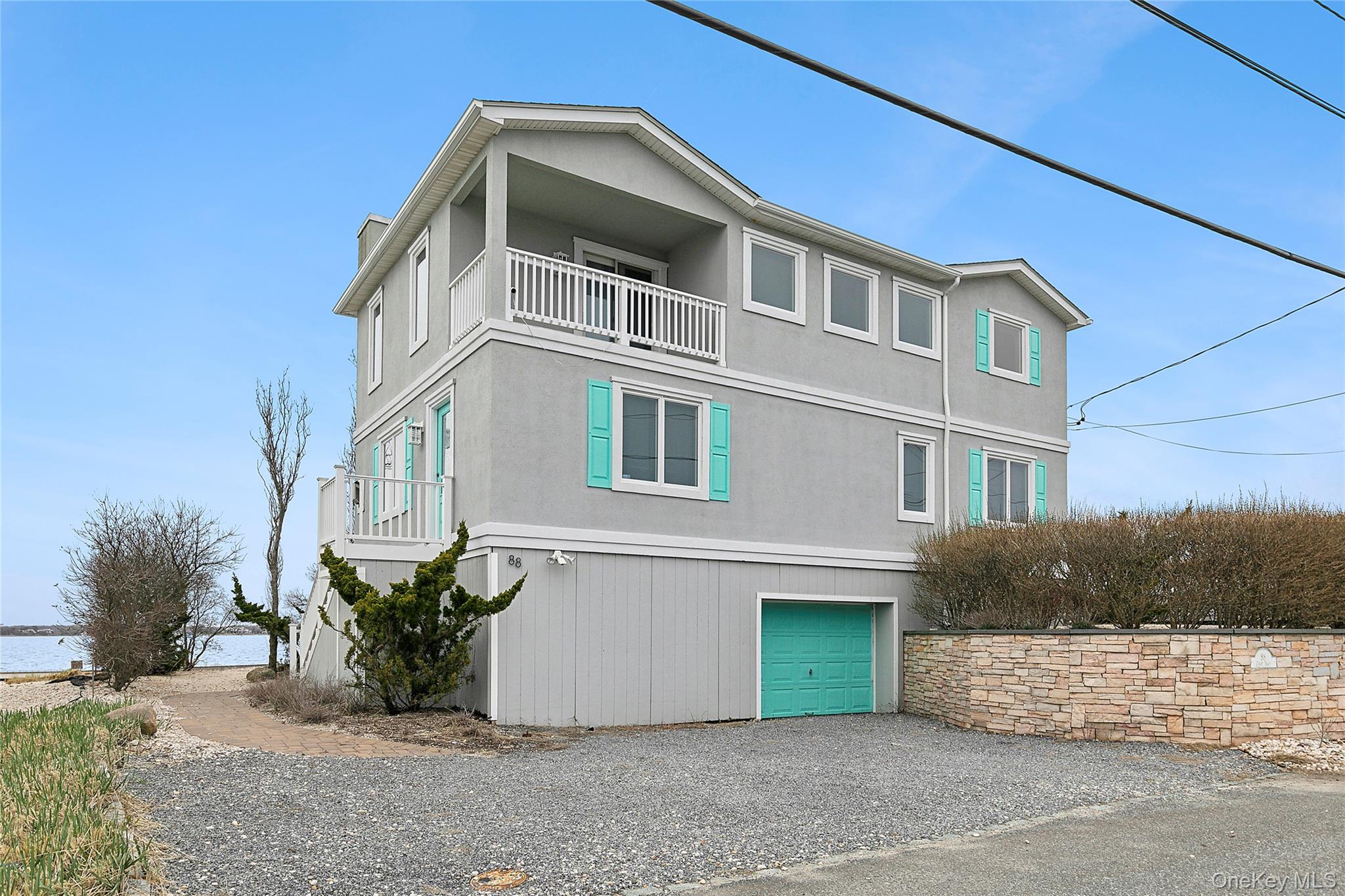 88 Point Road Westhampton Beach, NY 11978 - Photo 2 of 16 a front view of a house with a yard