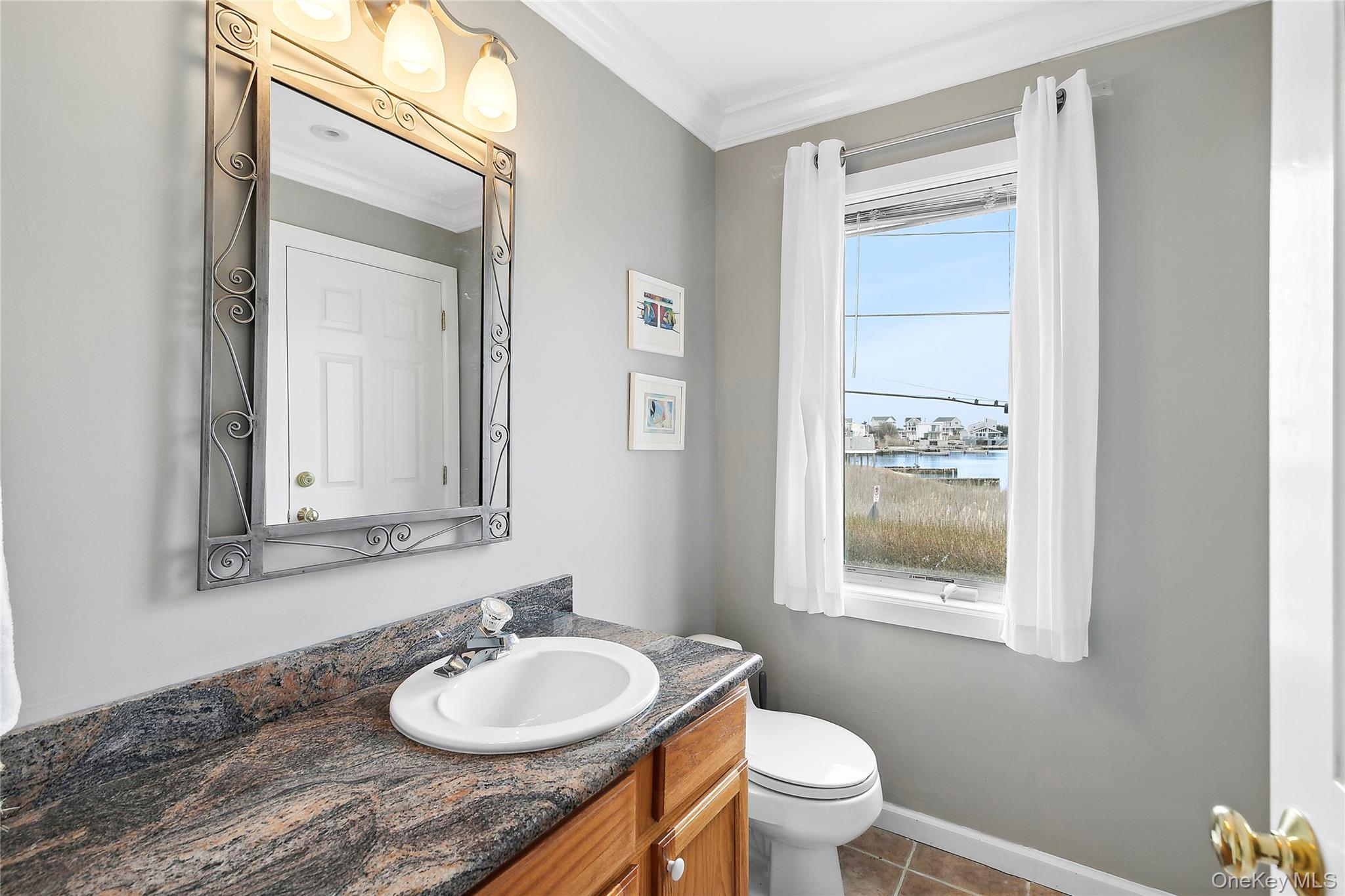 88 Point Road Westhampton Beach, NY 11978 - Photo 6 of 16 a bathroom with a granite countertop sink vanity mirror and toilet