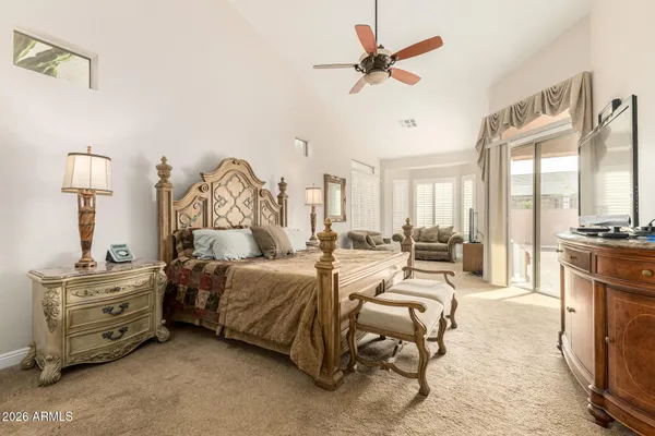 a spacious bedroom with a bed a couch and a chandelier