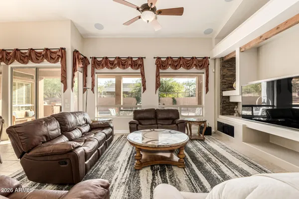 a living room with furniture fireplace and a large window