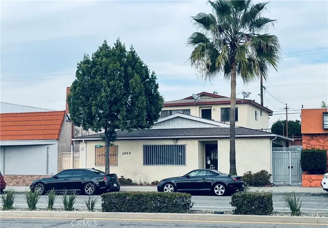 a front view of a house with a garden and parking