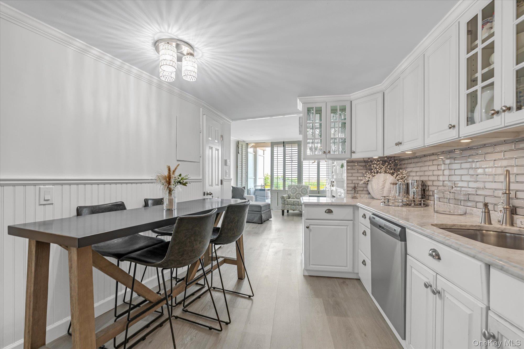 830 Shore Road, Unit 1F Long Beach, NY 11561 - Photo 9 of 21 a kitchen with a table chairs sink and cabinets