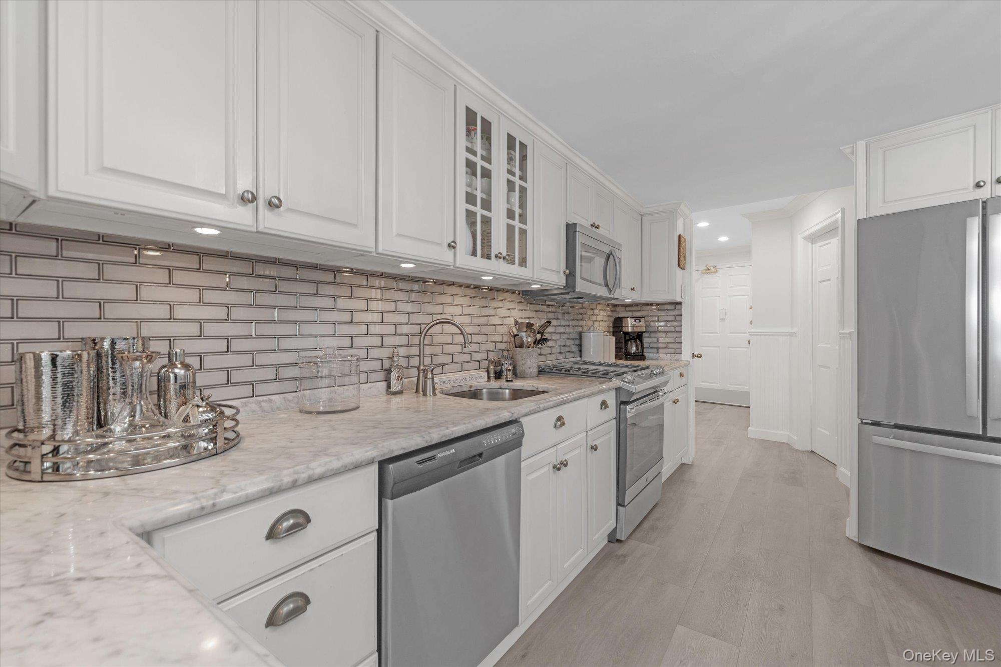 830 Shore Road, Unit 1F Long Beach, NY 11561 - Photo 10 of 21 a kitchen with stainless steel appliances granite countertop a sink stove and refrigerator