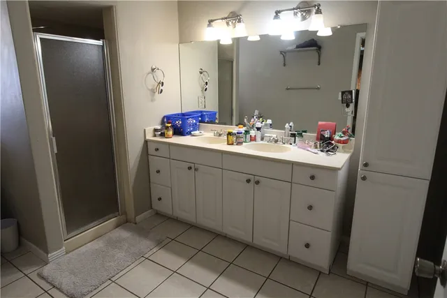 a bathroom with a double vanity sink mirror and shower