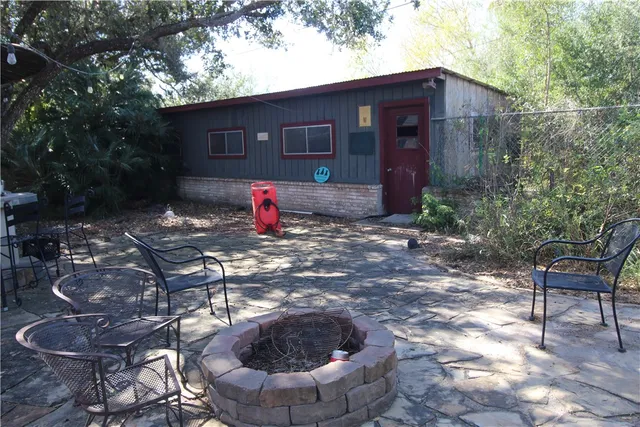 a view of a chairs and fire pit in the backyard
