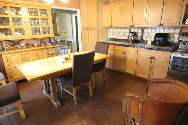 a kitchen with stainless steel appliances a table chairs and a refrigerator