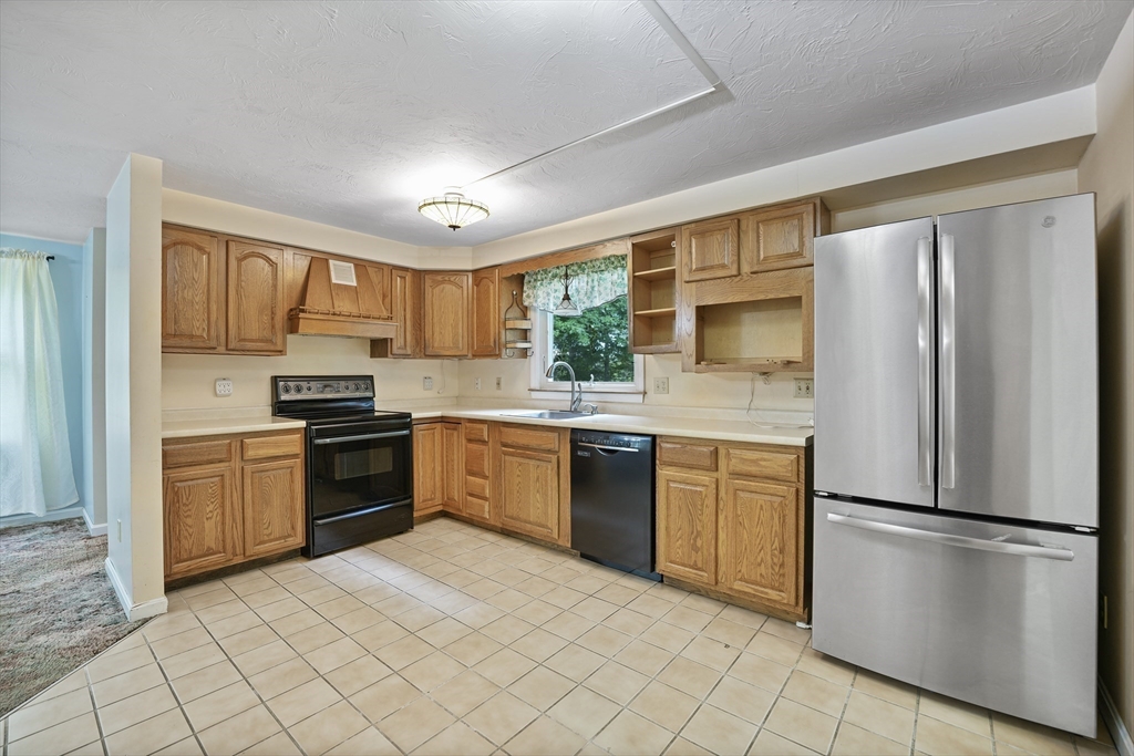 24 Springwood Drive Rochester, MA 02770 - Photo 8 of 21 a kitchen with granite countertop stainless steel appliances a refrigerator stove top oven and sink