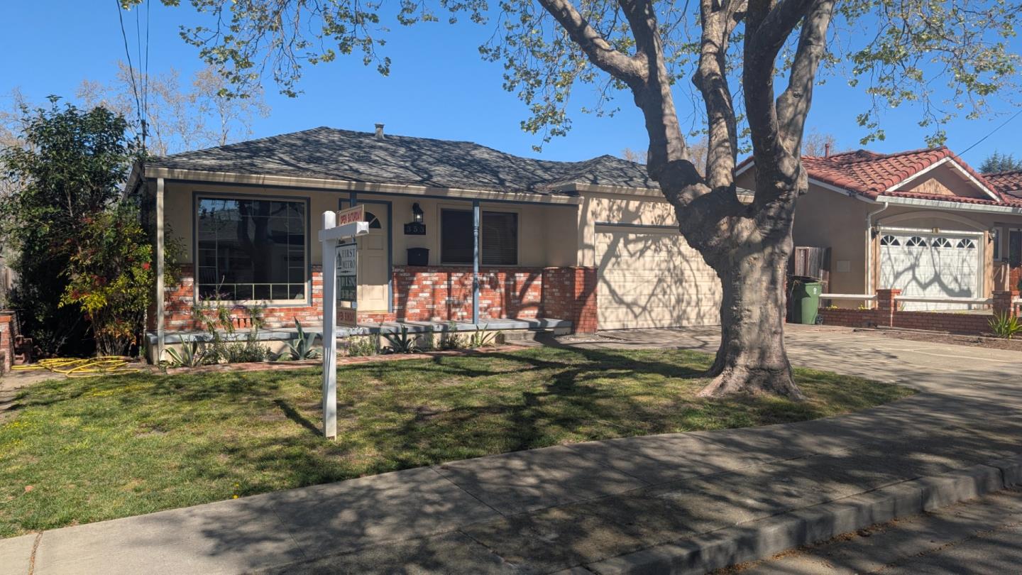 a view of a house with a tree in the yard
