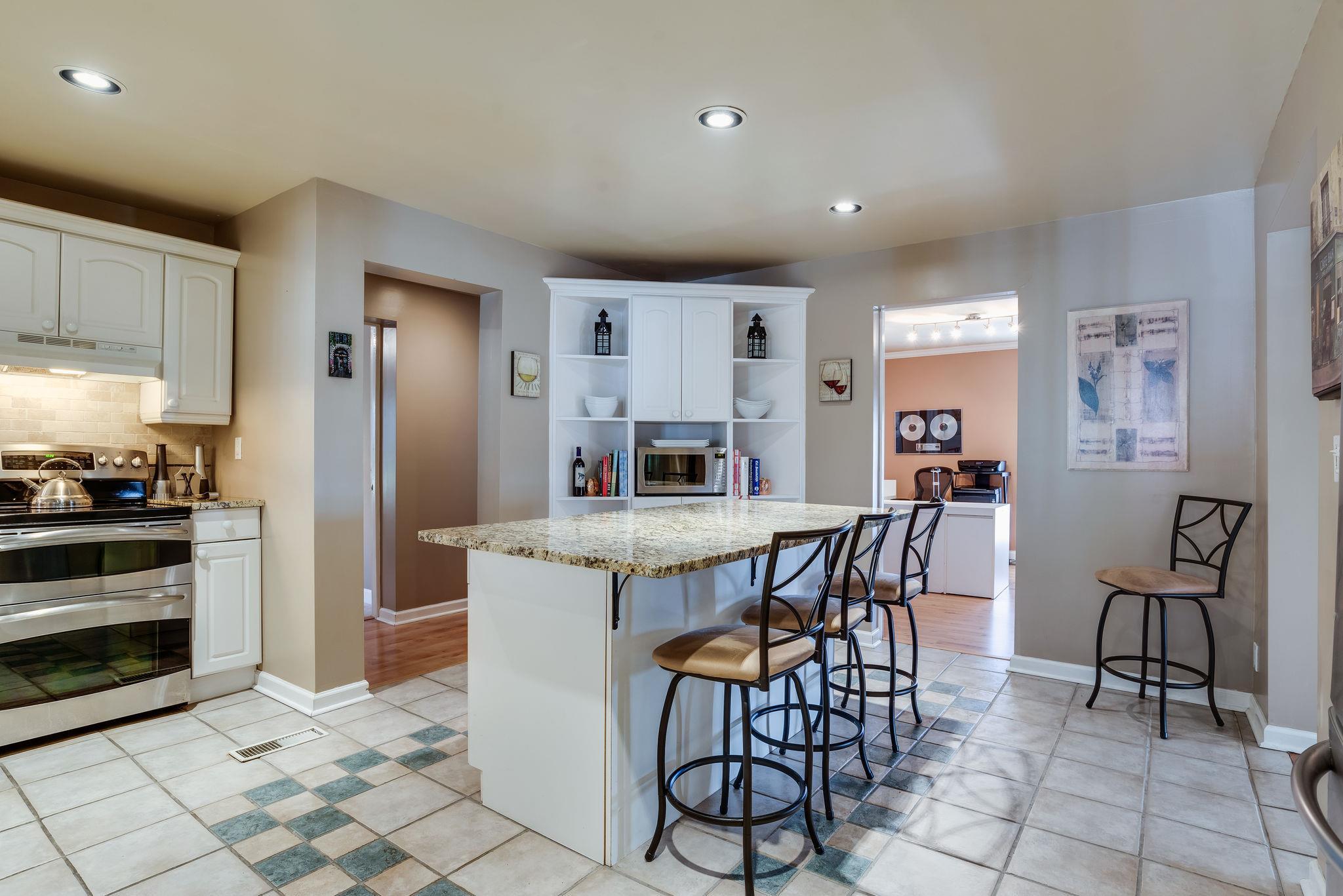 4133 Arno Road Franklin, TN 37064 - Photo 12 of 30 a kitchen with stainless steel appliances kitchen island granite countertop a dining table chairs and a refrigerator