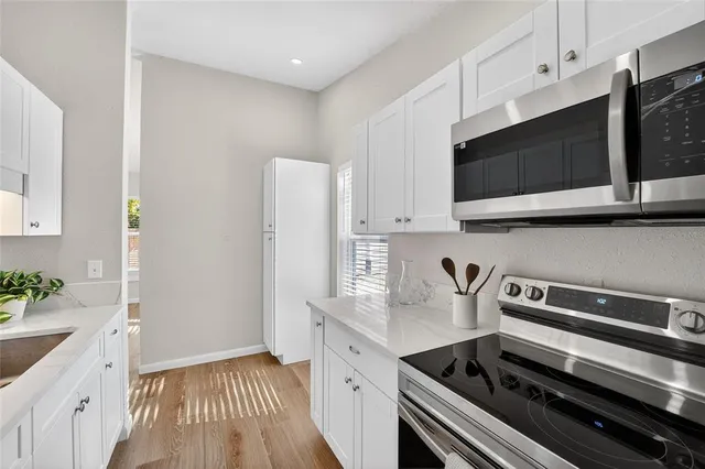 a kitchen with stainless steel appliances a stove microwave and sink
