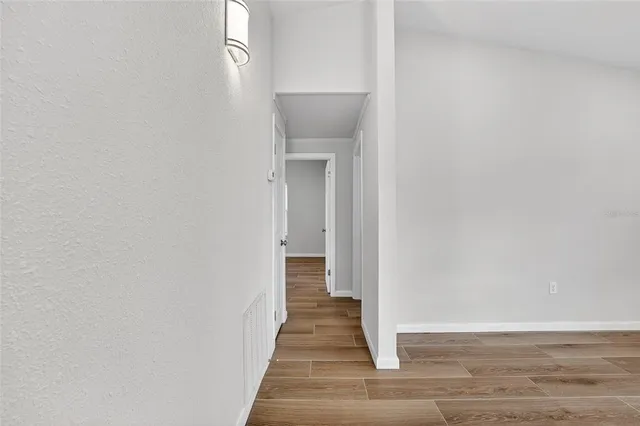 a view of a hallway with wooden floor and entryway