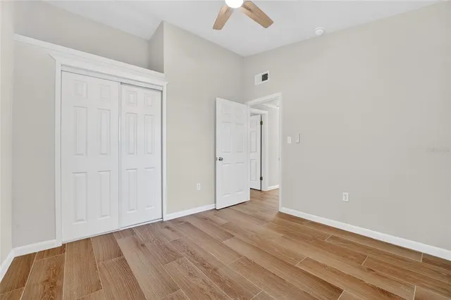 a view of an empty room with wooden floor