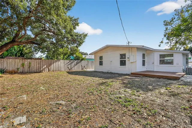 a view of a house with backyard and tree