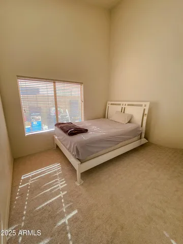 a bedroom with a bed and next to a window