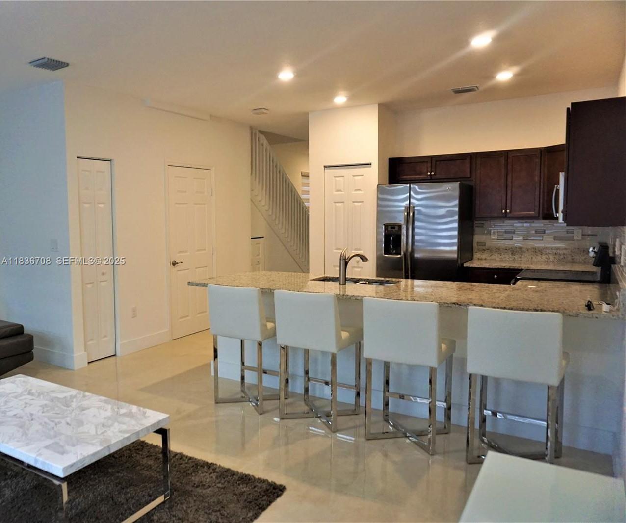 10498 West 33rd Way Hialeah, FL 33018 - Photo 11 of 28 a view of kitchen with stainless steel appliances kitchen island granite countertop a dining table chairs sink and cabinets