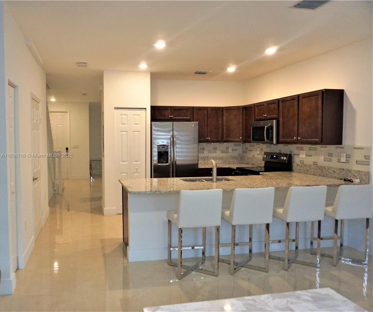10498 West 33rd Way Hialeah, FL 33018 - Photo 10 of 28 a large kitchen with kitchen island granite countertop a table and chairs in it