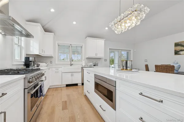 a kitchen with white cabinets stainless steel appliances and sink