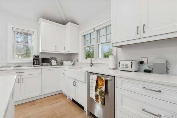 a kitchen with granite countertop white cabinets and white appliances