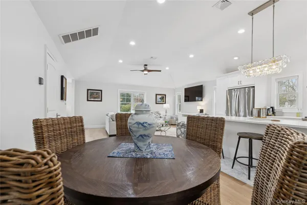 a living room with furniture a flat screen tv and kitchen view