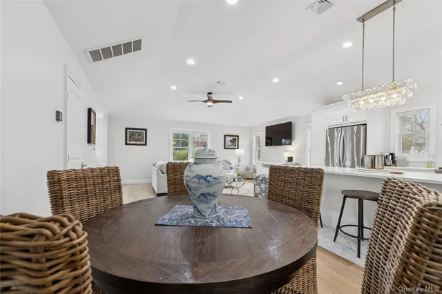 a living room with furniture a flat screen tv and kitchen view