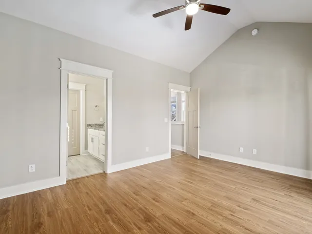 wooden floor in an empty room with a ceiling fan