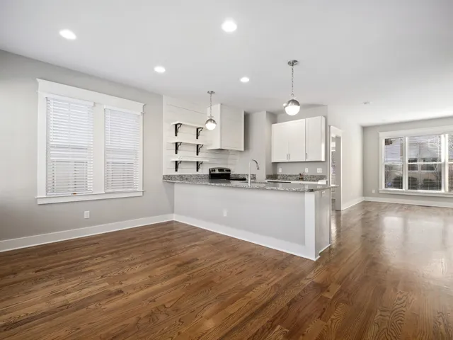 a view of kitchen with granite countertop cabinets and wooden floor