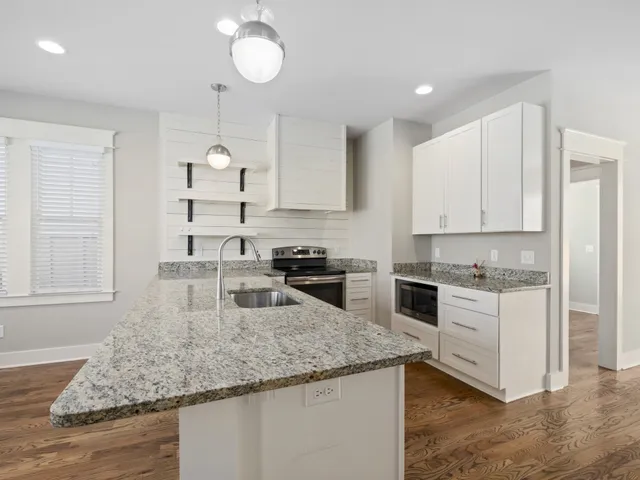 a kitchen with stainless steel appliances granite countertop a sink stove and cabinets