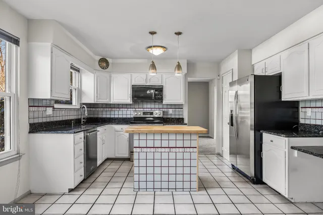 a kitchen with stainless steel appliances a refrigerator sink stove and cabinets
