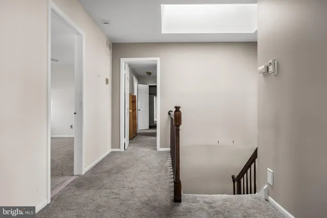 an empty room with a fan & windows