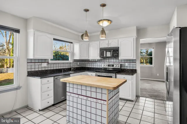 a kitchen with stainless steel appliances a refrigerator sink stove microwave and cabinets