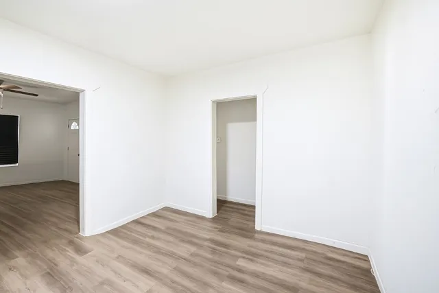a view of an empty room with wooden floor