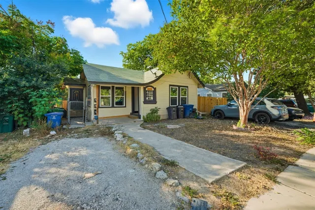 a front view of a house with a yard and trees