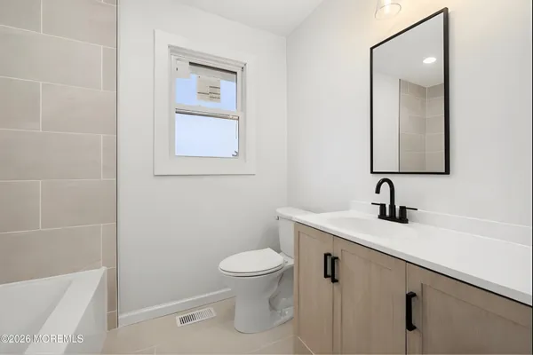 an empty room with wooden floor and window