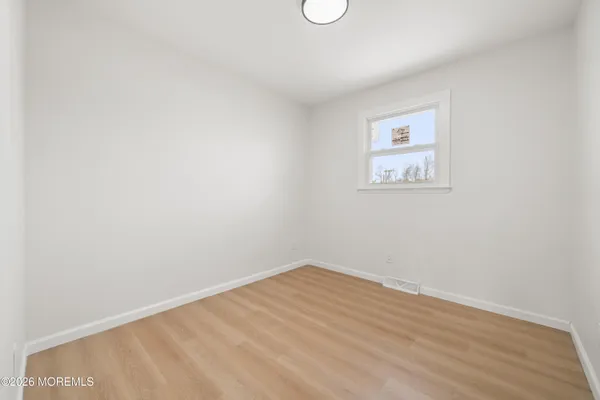an empty room with a painting on the wall