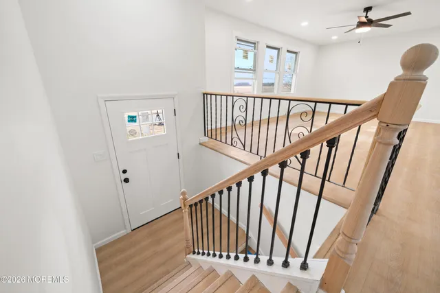a view of staircase with railing and white walls
