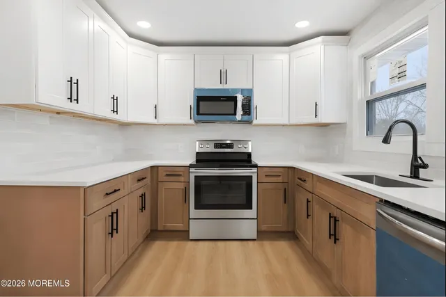 a kitchen with cabinets stainless steel appliances and a counter space