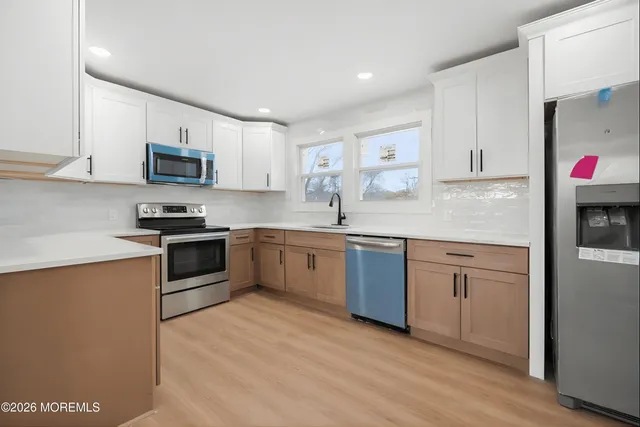 a kitchen with granite countertop a sink cabinets and stainless steel appliances